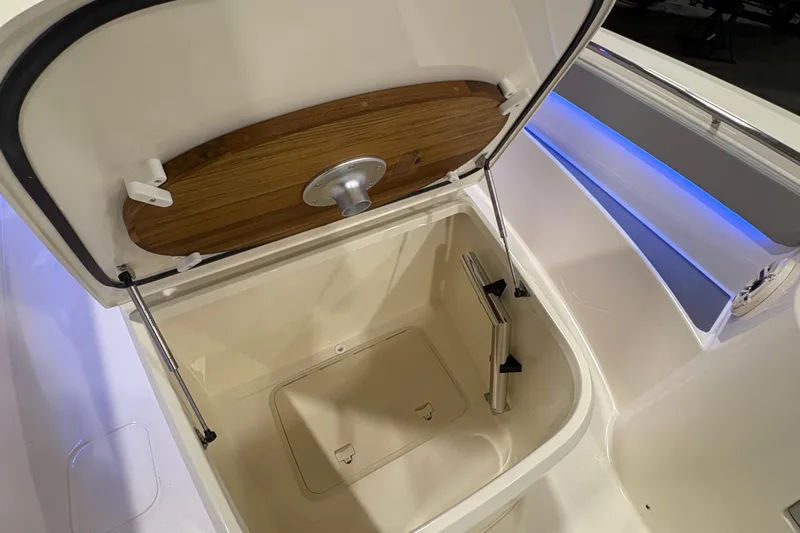  Yacht Photos Pics Open storage compartment on 2026 Scout 288 LXF boat with wooden lid and blue lighting.