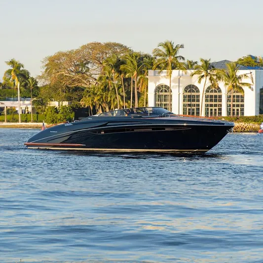  Yacht Photos Pics 2014 Riva Rivarama Super 44 yacht cruising near palm trees and luxury villa.