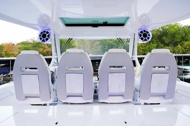 Only Fins Yacht Photos Pics 2021 Regal 38 SAV boat interior with four white seats and modern audio system.