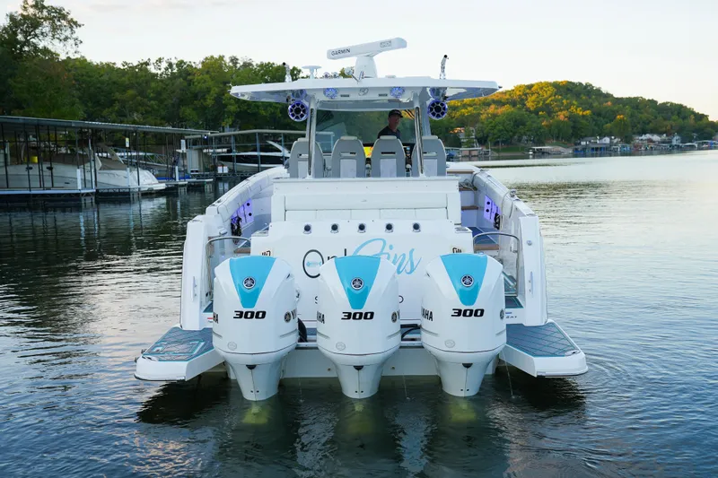 Only Fins Yacht Photos Pics 2021 Regal 38 SAV boat with triple Yamaha 300 engines on a serene lake.