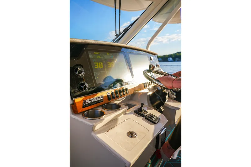 Only Fins Yacht Photos Pics 2021 Regal 38 SAV boat dashboard with steering wheel and digital display.