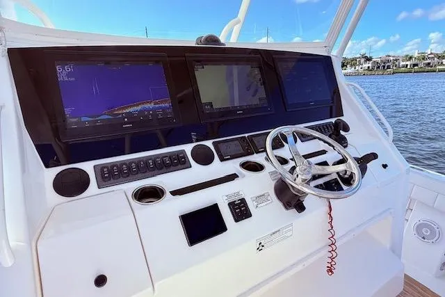  Yacht Photos Pics Control panel of a 2017 Regulator 41 boat with navigation screens and steering wheel.