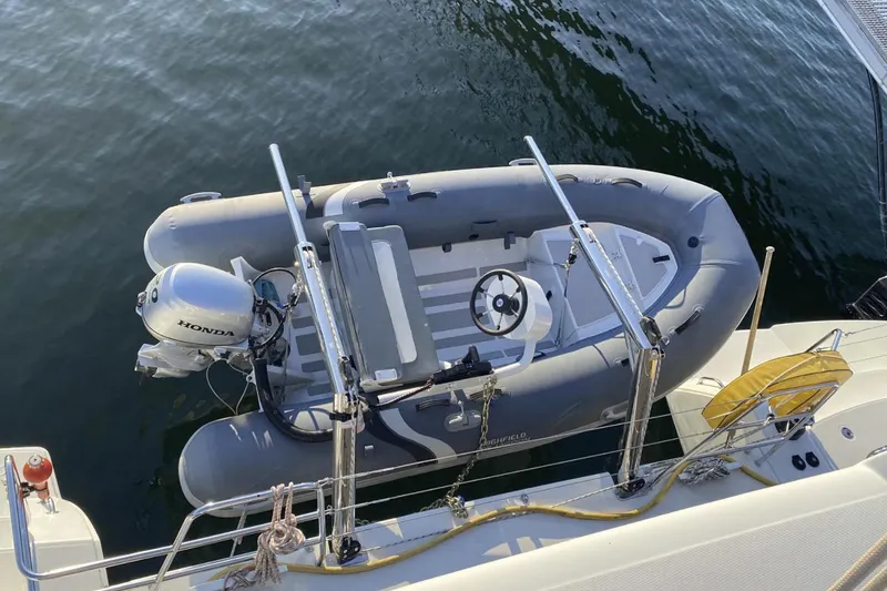 Why Not Yacht Photos Pics Inflatable dinghy with Honda motor on Lagoon 450F catamaran, 2019 model, docked on water.