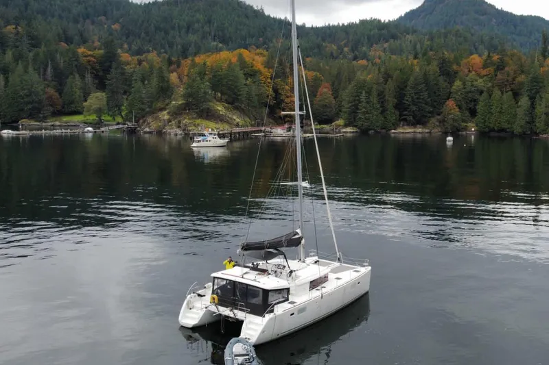 Why Not Yacht Photos Pics 2019 Lagoon 450F catamaran anchored in a serene forested bay.
