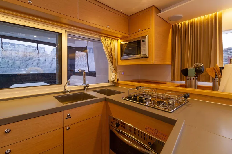 Why Not Yacht Photos Pics Modern kitchen interior of 2019 Lagoon 450F yacht with stove, sink, and microwave.