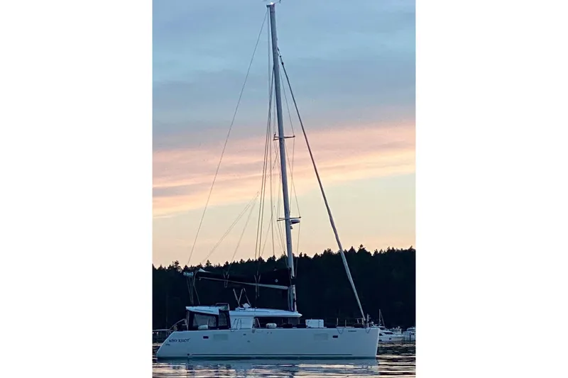 Why Not Yacht Photos Pics 2019 Lagoon 450F catamaran sailing at sunset with serene water reflections.