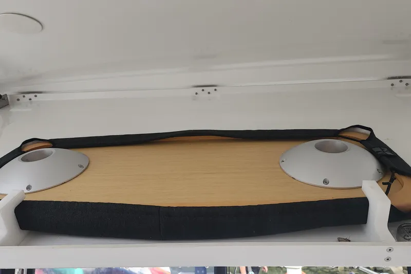 Why Not Yacht Photos Pics Storage compartment in a 2019 Lagoon 450F yacht, featuring a wooden panel and metal fixtures.