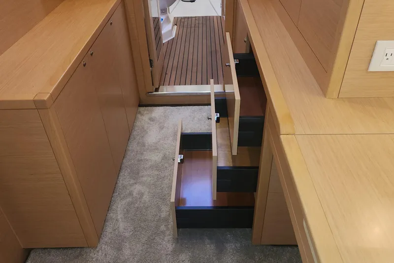 Why Not Yacht Photos Pics Interior of 2019 Lagoon 450F yacht with open wooden drawers and carpeted floor.