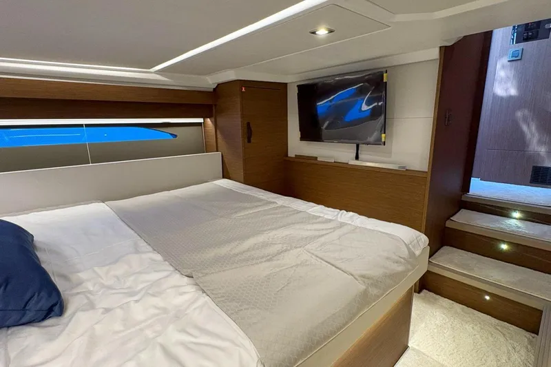  Yacht Photos Pics Luxurious bedroom interior of 2026 Wellcraft 44 Explorer yacht with modern design and TV.
