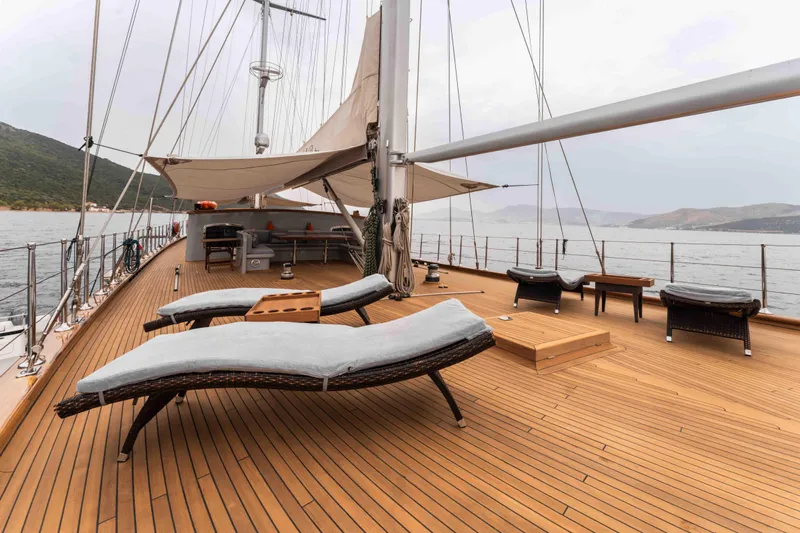 Le Pietre Yacht Photos Pics Luxurious deck of a 2009 custom sailing yacht with sun loungers and scenic ocean view.