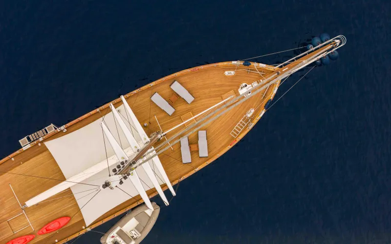 Le Pietre Yacht Photos Pics Aerial view of a 2009 custom sailing yacht with wooden deck and lounging area.