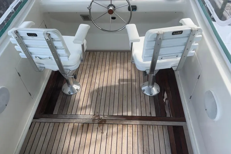 Jonny Wasabi Yacht Photos Pics Cockpit of 2002 Custom 64 Stuart Catamarans with wooden flooring and two white seats.