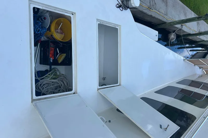 Jonny Wasabi Yacht Photos Pics Open storage compartments on 2002 Custom 64 Stuart Catamarans deck, showing ropes and cleaning supplies.