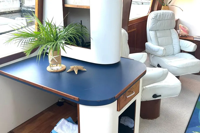 Jonny Wasabi Yacht Photos Pics Luxurious interior of 2002 Custom 64 Stuart Catamarans with white chairs and decorative plants.