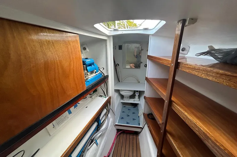 Jonny Wasabi Yacht Photos Pics Interior of 2002 Custom 64 Stuart Catamarans with wooden shelves and compact bathroom.
