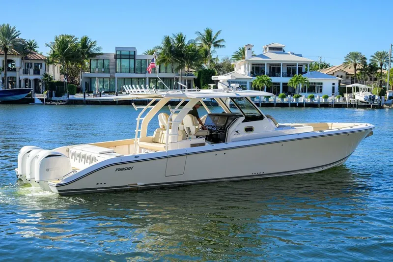 Leap Year Yacht Photos Pics 2018 Pursuit S 408 Sport boat cruising on a sunny waterfront with luxury homes.