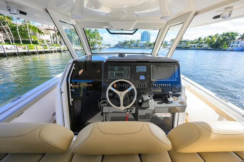 Leap Year Yacht Photos Pics 2018 Pursuit S 408 Sport boat cockpit with modern controls and waterfront view.