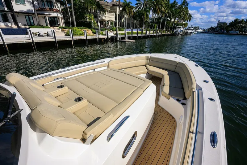 Leap Year Yacht Photos Pics 2018 Pursuit S 408 Sport boat with luxurious seating, docked by waterfront homes.