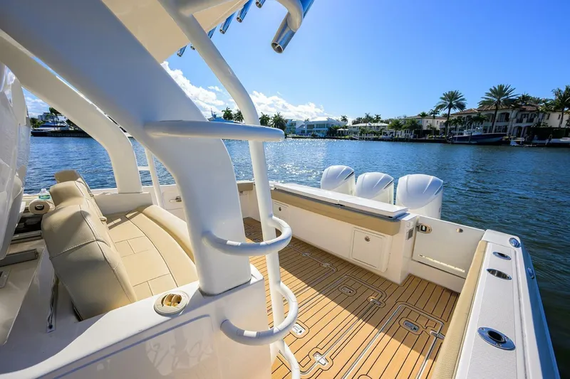 Leap Year Yacht Photos Pics 2018 Pursuit S 408 Sport boat with luxurious deck, docked by waterfront homes.