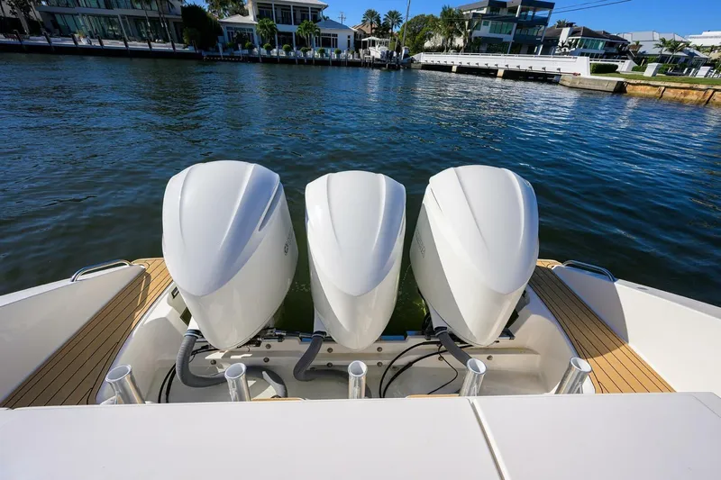 Leap Year Yacht Photos Pics 2018 Pursuit S 408 Sport boat with triple outboard engines on a calm waterfront.