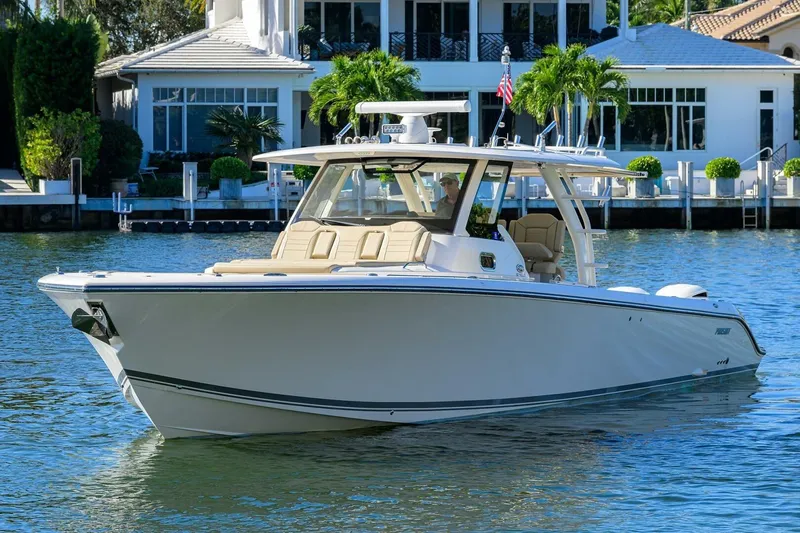 Leap Year Yacht Photos Pics 2018 Pursuit S 408 Sport boat on water near luxury waterfront home.