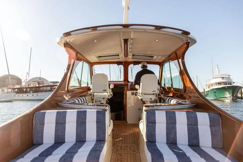 Ruth Ann Yacht Photos Pics 2023 Hinckley Picnic Boat 34 S interior with striped seating, docked at marina.