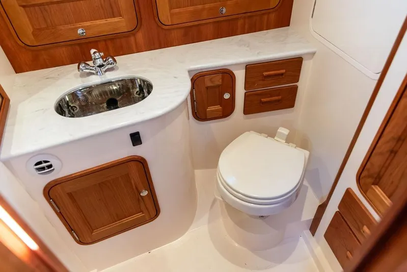Ruth Ann Yacht Photos Pics 2023 Hinckley Picnic Boat 34 S bathroom with wooden cabinetry and modern fixtures.
