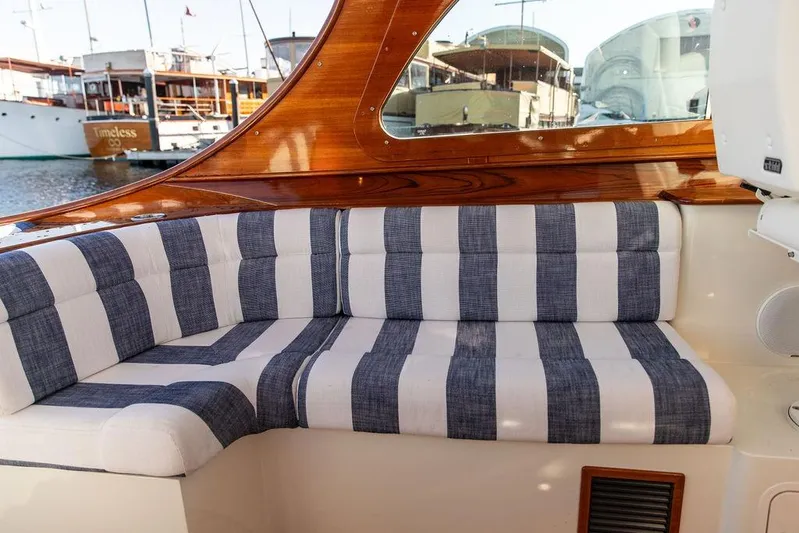 Ruth Ann Yacht Photos Pics 2023 Hinckley Picnic Boat 34 S interior with striped seating and wooden accents.