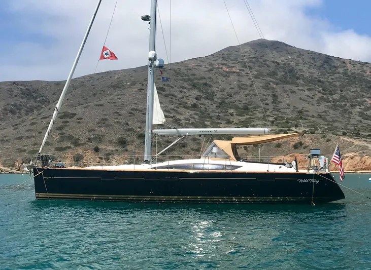 Dharma Yacht Photos Pics 2013 Jeanneau 57 sailboat anchored in scenic bay with mountainous backdrop.