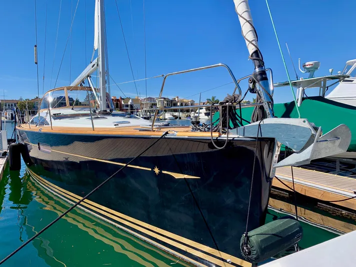 Dharma Yacht Photos Pics 2013 Jeanneau 57 sailboat docked in marina, sleek design, sunny day.
