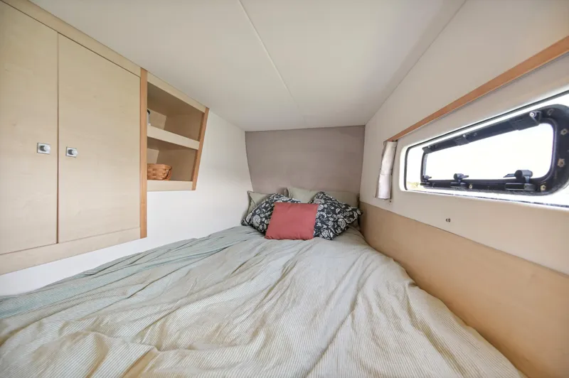Zephyr Yacht Photos Pics Cozy bedroom in 2016 Catana 42 catamaran with window and storage shelves.