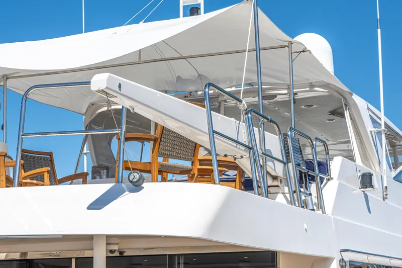  Yacht Photos Pics 2005 Pacific Mariner 85 Motor Yacht with shaded upper deck and wooden chairs.