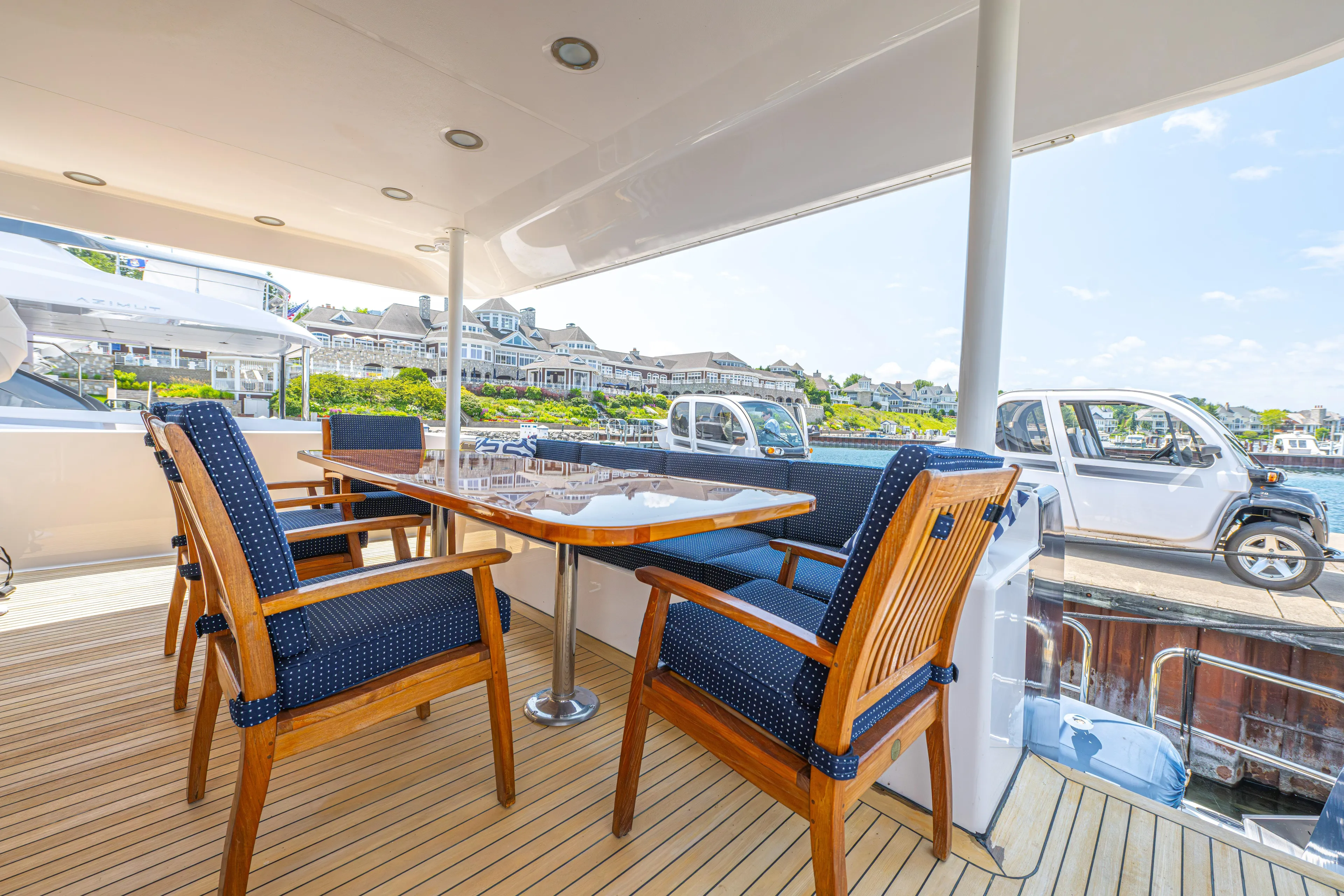  Yacht Photos Pics Outdoor dining area on a 2005 Pacific Mariner 85 Motor Yacht with wooden chairs and table.