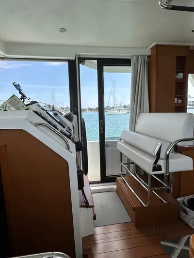  Yacht Photos Pics Interior view of 2021 Beneteau Swift Trawler 41 Fly, featuring helm and seating area.