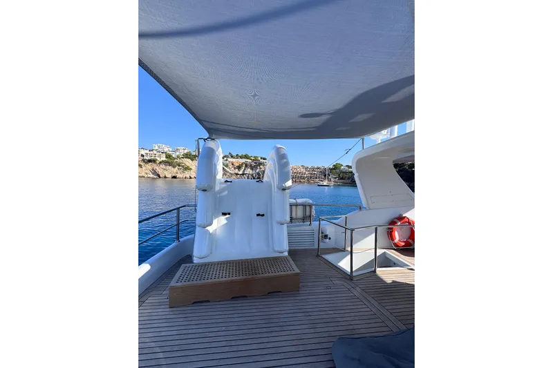  Yacht Photos Pics Sanlorenzo SL88 yacht deck with shaded seating, overlooking serene coastal waters.