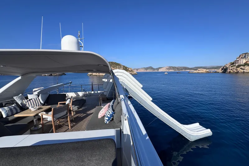  Yacht Photos Pics Luxurious 2000 Sanlorenzo SL88 yacht with slide, anchored in scenic coastal waters.