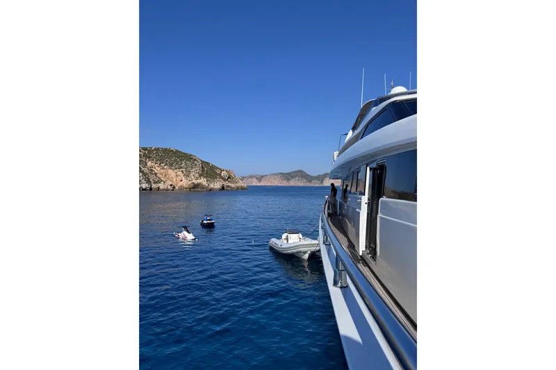  Yacht Photos Pics Sanlorenzo SL88 yacht from 2000 anchored near scenic coastal cliffs.