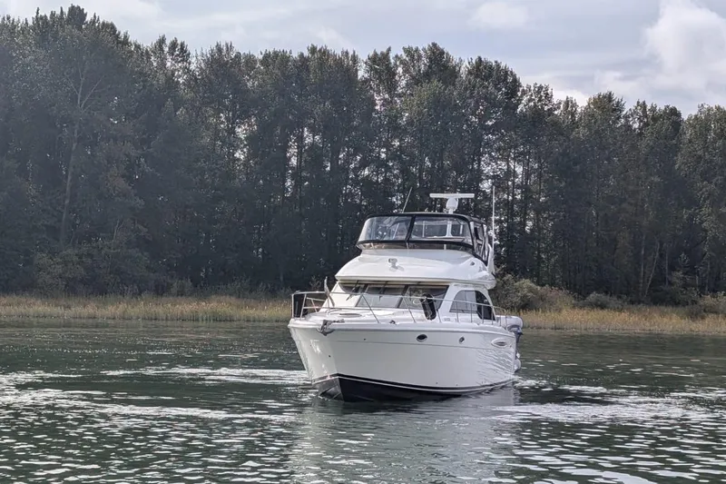 High Flyer Yacht Photos Pics 2007 Meridian 411 Sedan Bridge yacht cruising on a serene lake with forest backdrop.