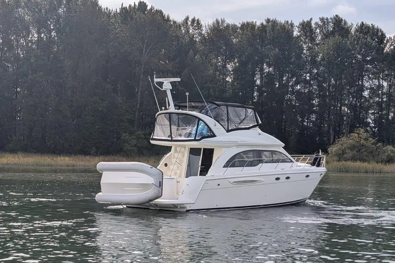 High Flyer Yacht Photos Pics 2007 Meridian 411 Sedan Bridge yacht on calm water near forested shoreline.