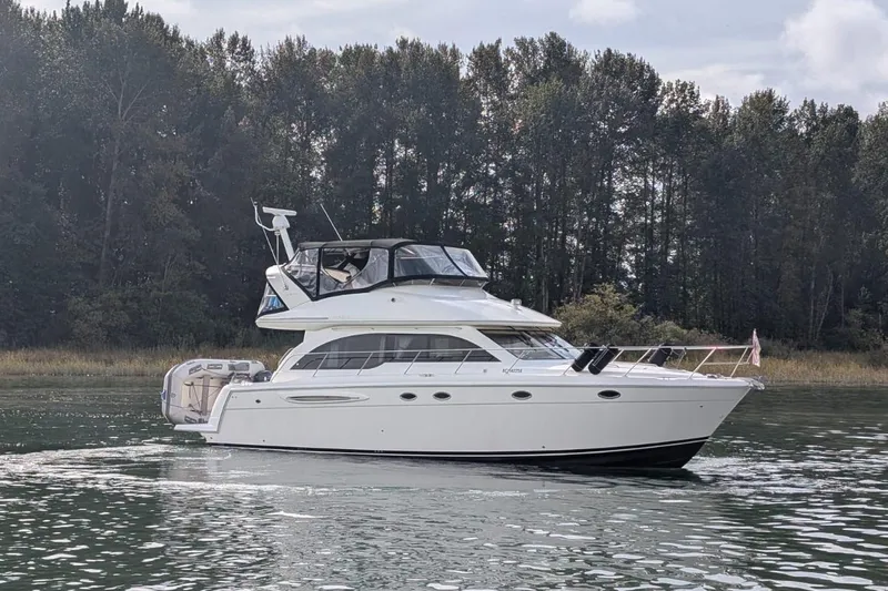 High Flyer Yacht Photos Pics 2007 Meridian 411 Sedan Bridge yacht cruising on a serene lake with forest backdrop.