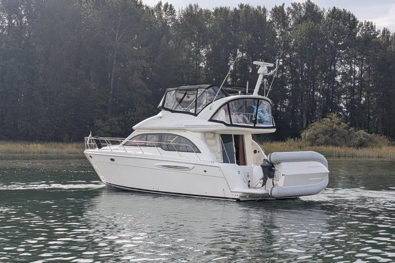 High Flyer Yacht Photos Pics 2007 Meridian 411 Sedan Bridge yacht cruising on a calm lake near a forest.