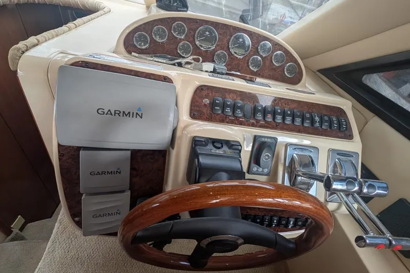 High Flyer Yacht Photos Pics 2007 Meridian 411 Sedan Bridge helm with Garmin navigation and wood-trimmed steering wheel.