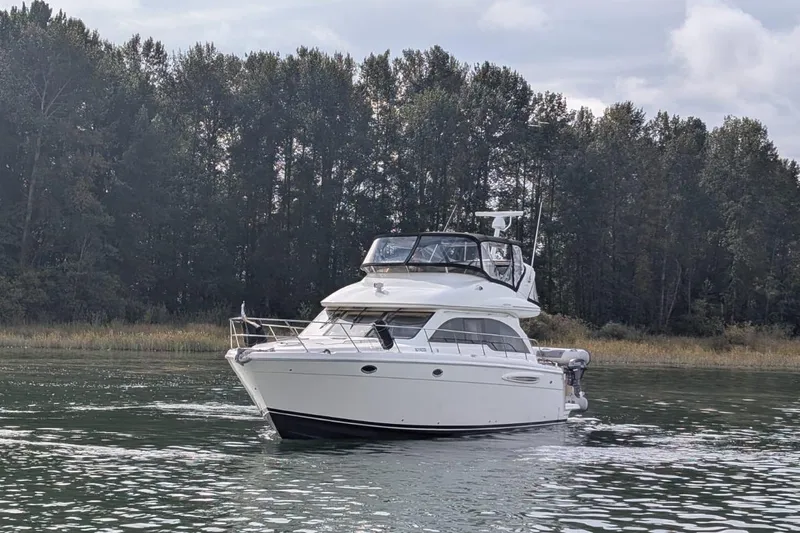 High Flyer Yacht Photos Pics 2007 Meridian 411 Sedan Bridge yacht cruising on a serene lake with forest backdrop.