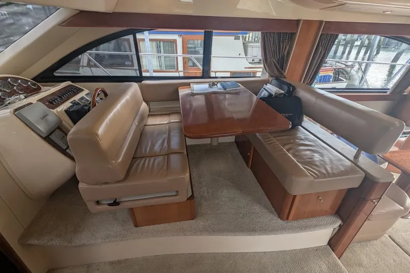 High Flyer Yacht Photos Pics Interior of 2007 Meridian 411 Sedan Bridge with leather seating and wooden table.