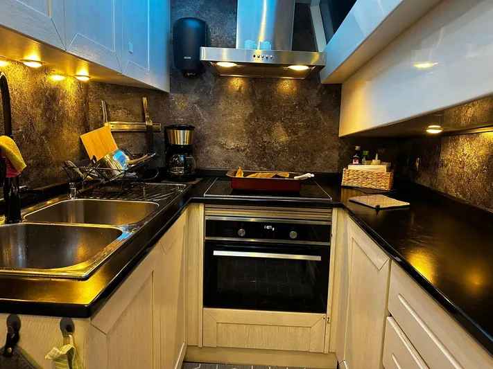  Yacht Photos Pics Modern kitchen in a 2009 Conam 65 Flybridge yacht, featuring sleek countertops and ambient lighting.