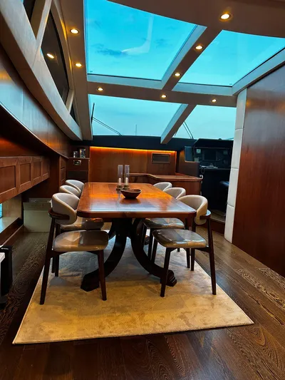  Yacht Photos Pics Luxurious dining area on a 2009 Conam 65 Flybridge yacht with skylight and elegant wood finishes.