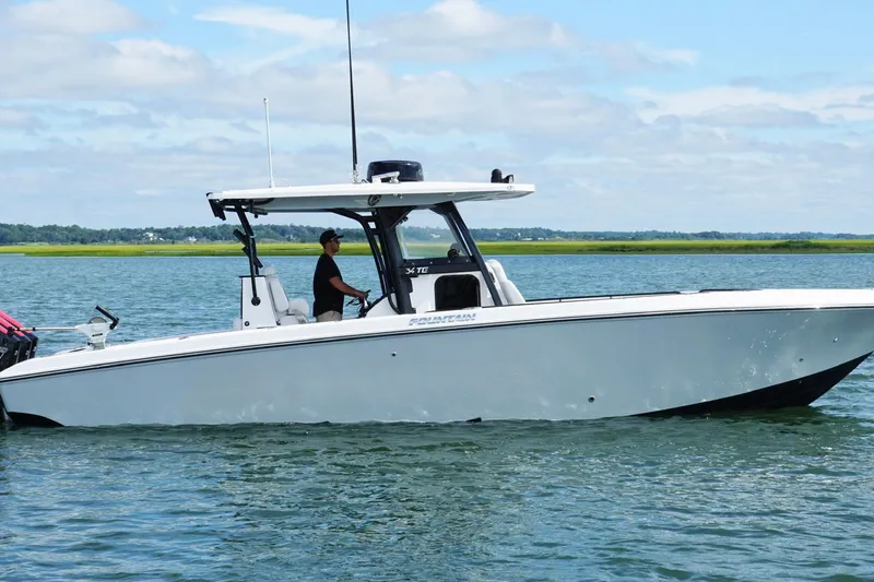  Yacht Photos Pics 2024 Fountain 34 TE boat cruising on calm water under a clear sky.