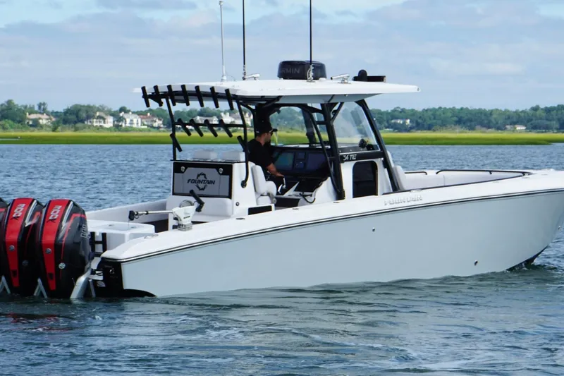  Yacht Photos Pics 2024 Fountain 34 TE boat cruising on a calm lake with twin outboard engines.