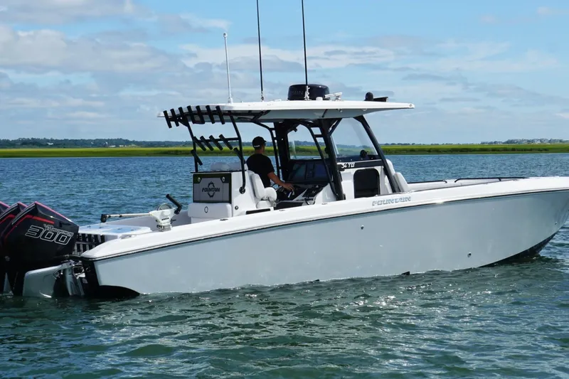  Yacht Photos Pics 2024 Fountain 34 TE boat cruising on calm water under a clear sky.