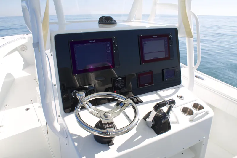  Yacht Photos Pics 2014 Yellowfin 32 Offshore boat console with steering wheel and navigation screens.